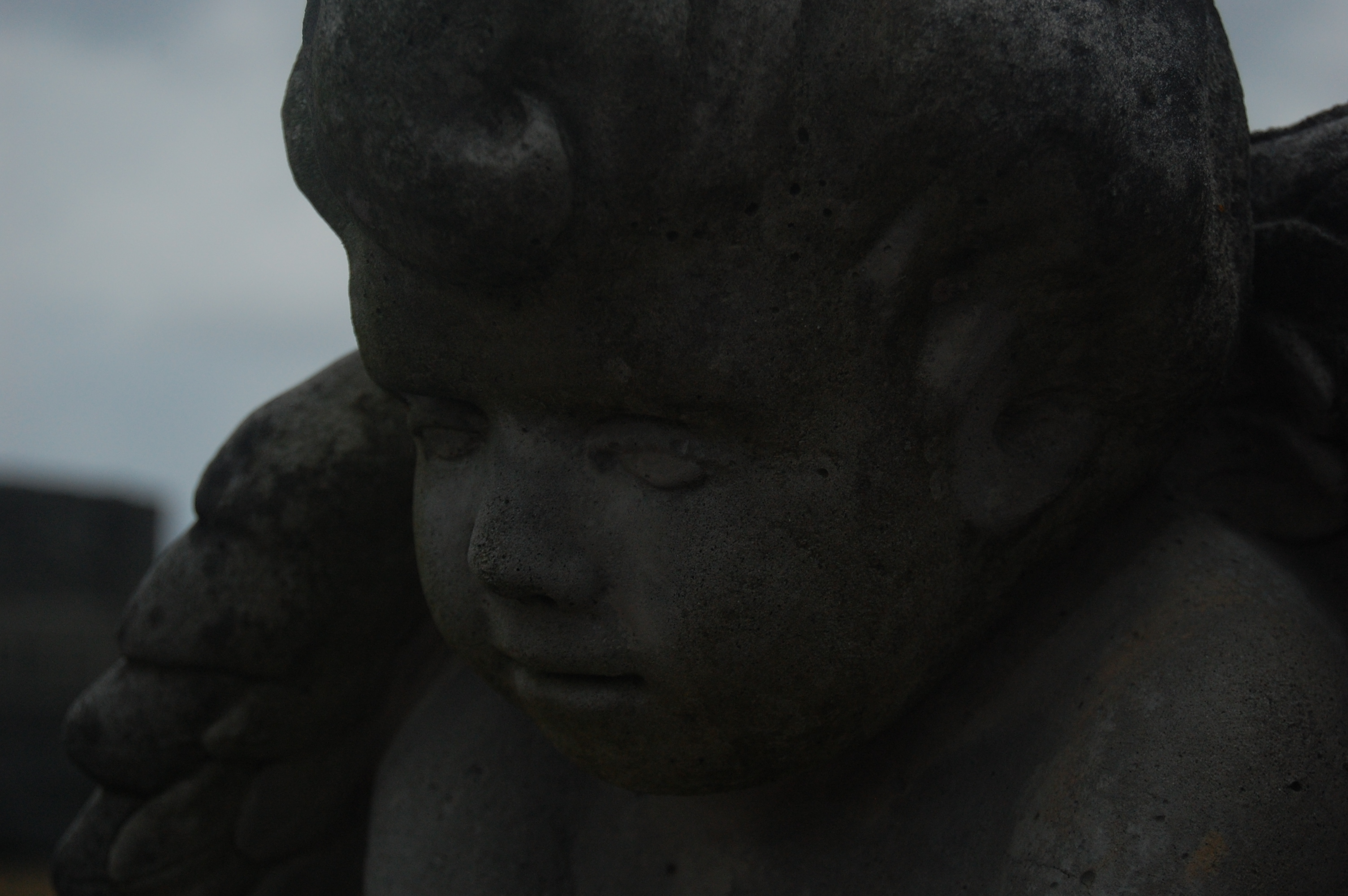 an up close shot of an angel statue in the rain