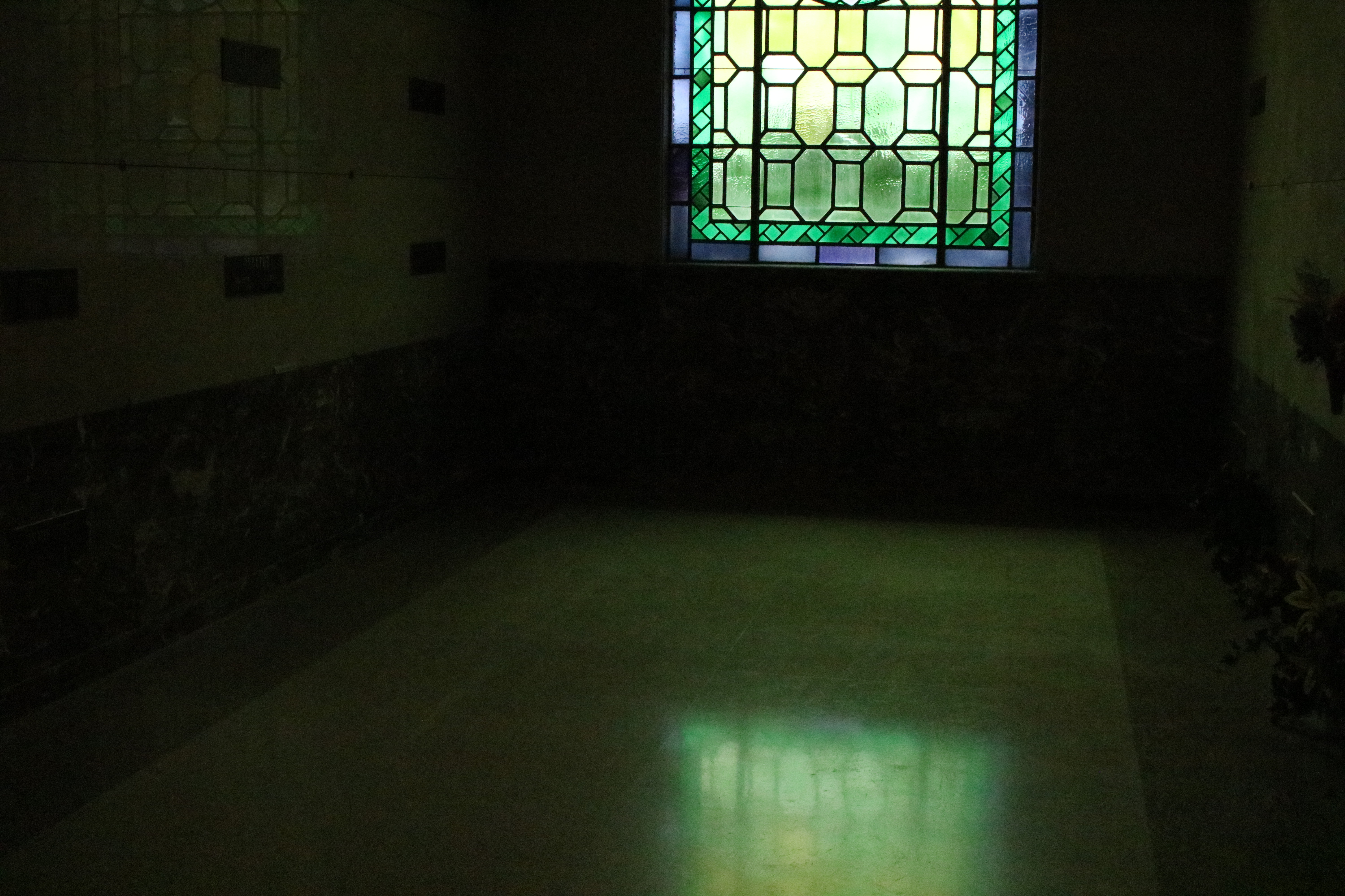 a green tinted photo of the inside of a mausoleum in the biggest cemetery in atlanta